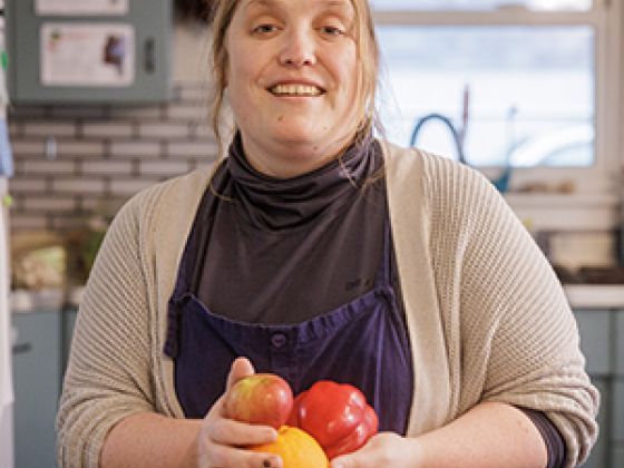 A woman holding vegetables.