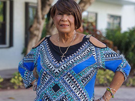 A woman smiling while standing outside.