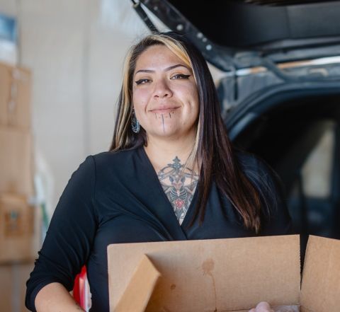 A woman holding a box of food.