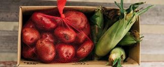 Corn and potatoes in wooden box