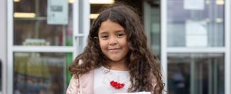 Juana Saucero's daughter smiling in front of a building.